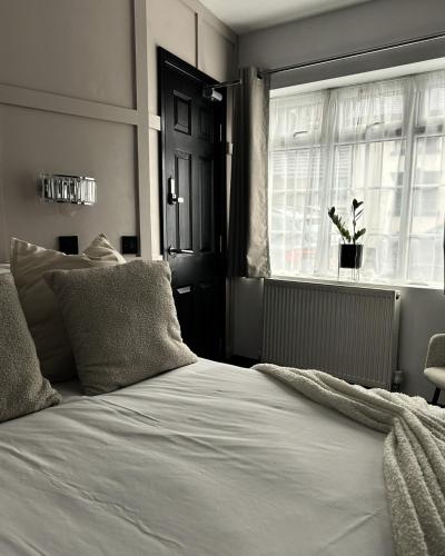 a bedroom with a white bed and a window at Frankies Lodge in Disley