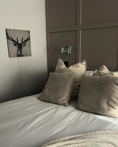 a bed with pillows and a picture of a deer on it at Frankies Lodge in Disley