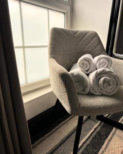 a chair with towels on it next to a window at Frankies Lodge in Disley
