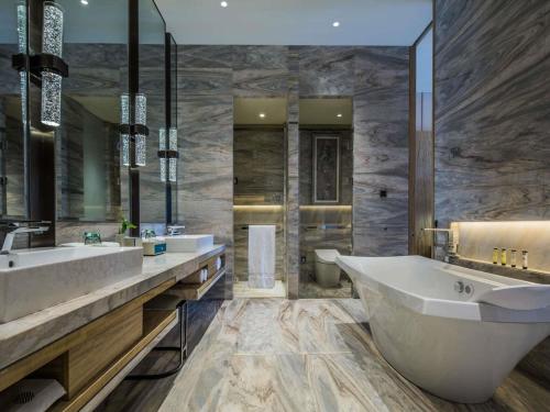 a bathroom with two sinks and a large tub at 太原富力铂尔曼大酒店 in Taiyuan
