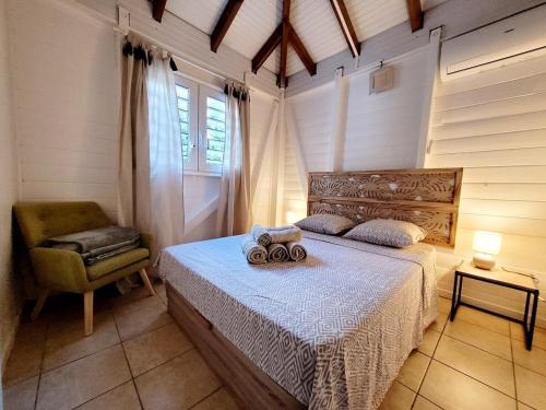 a bedroom with a bed and a chair and a window at Ti Kaz Robin in Trois-Rivières
