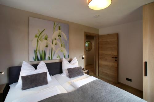 a bedroom with a white bed with white pillows at Annika Apartments summer card included in Zell am See