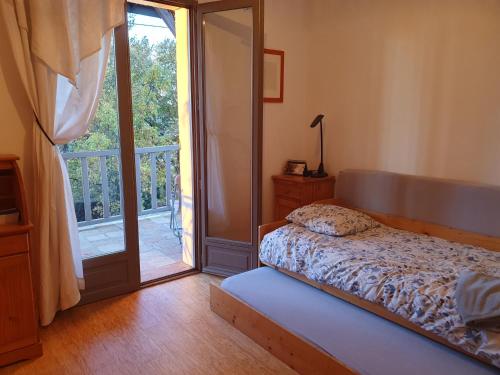 a bedroom with a bed and a sliding glass door at Las Irondas in Moissac