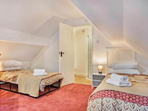 a attic bedroom with two beds with towels on them at 3 Bed in Ashbourne oc-94309 in Windley
