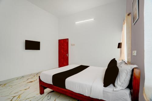 a bedroom with a bed in a white room at Super Hotel Redmoon Residency Elite in Chennai
