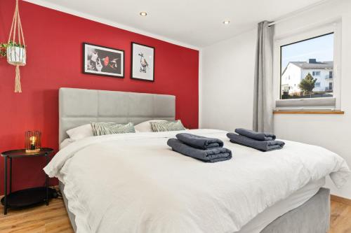 a bedroom with a large white bed with red walls at KOLIBRI - Design Maisonette - Nintendo Switch, Streaming, Bikestore, E-Wallbox in Marburg an der Lahn