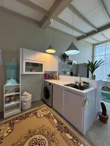 a kitchen with a sink and a dishwasher at Gyuzel villa di lembang in Citeureup 1