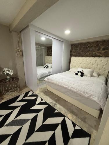 a bedroom with a large bed and a mirror at Gyuzel villa di lembang in Citeureup 1