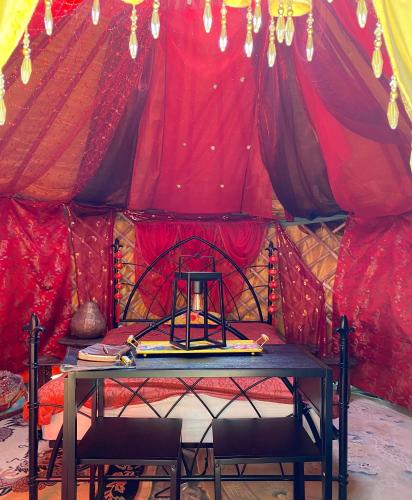 a room with a table and chairs in a tent at The Shangri La Sunset Yurt in Tenbury