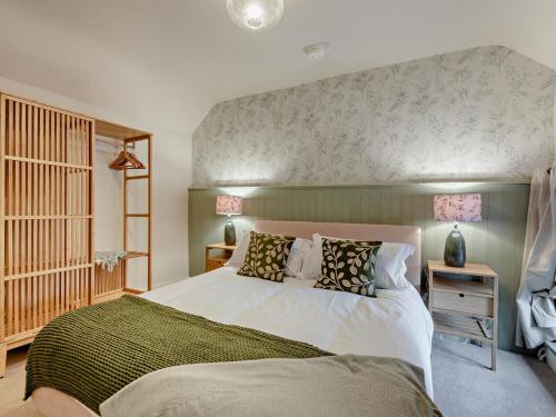 a bedroom with a large bed with a green blanket at 2 Bed in Buxton oc-95993 in Hartington