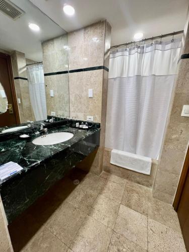 a bathroom with a sink and a shower at Intercity Tower Hotels in San Pedro Sula