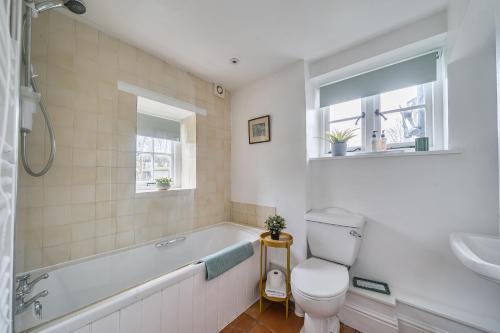 a bathroom with a tub and a toilet and a sink at South Cottage in Sherborne