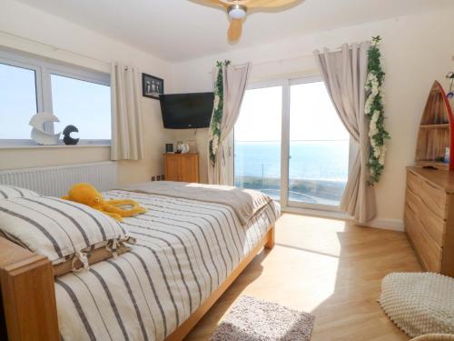 a bedroom with a bed and a large window at Snowdonia View in Pwllheli