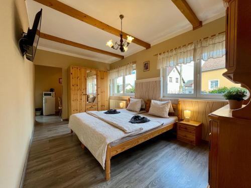 a bedroom with a bed and two windows at Penzion Žírovice in Františkovy Lázně