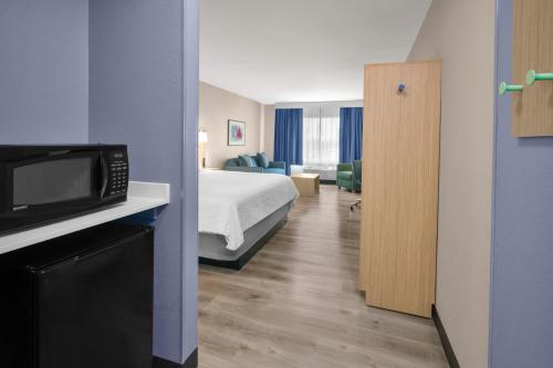 a hotel room with a bed and a microwave at Garner Hotel Lincoln North by IHG in Lincoln