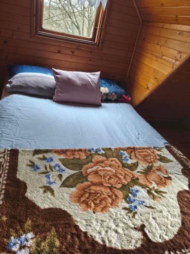 a bed in a room with a rug on it at Zofiówka las in Zofiówka