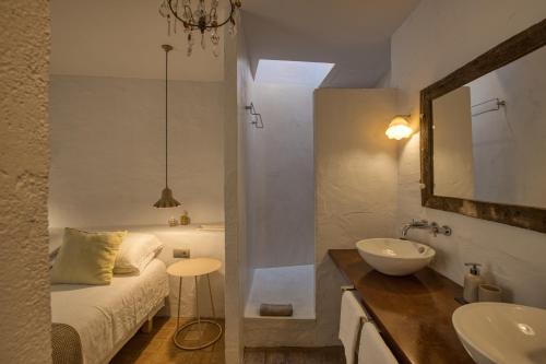 a bathroom with a sink and a bed and a mirror at Les Hamaques hotel in Viladamat
