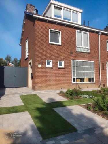 a brick house with a lawn in front of it at Saskia's logeerhuis in Arnhem