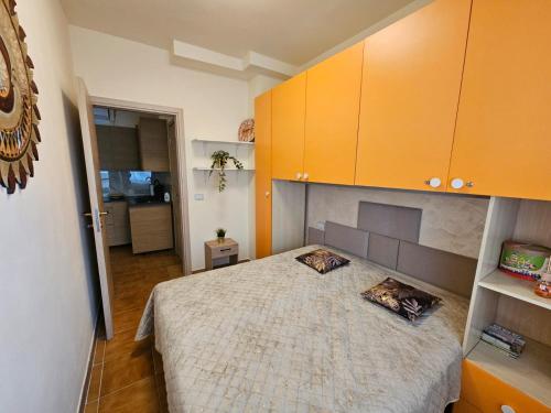 a bedroom with a bed and orange cabinets at Appartamento Rosa Calabria in Roseto Capo Spulico