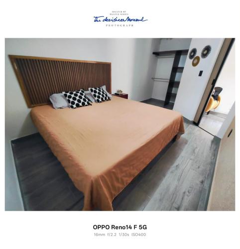 a bedroom with a large bed with a wooden headboard at Casa tierno amanecer in Xpujil