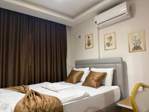 a bedroom with a bed with white sheets and brown pillows at Nativo Otel in Antalya