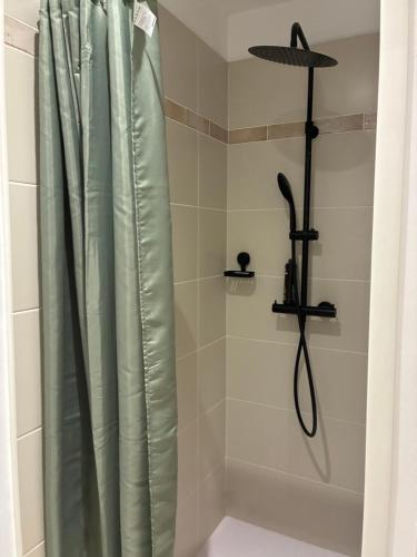 a shower with a shower curtain in a bathroom at Les clés de Jules in Gruissan