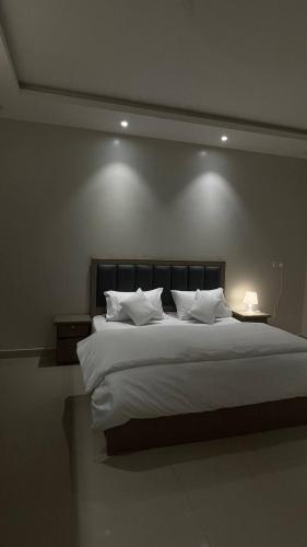 a bedroom with a large bed with white sheets and pillows at شـقـة بغـرفـتـيـن Two rooms in Al Kharj