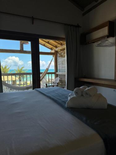 a bedroom with a bed with two teddy bears on it at Tamikuã Mar Pousada in Caraíva