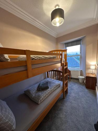 a bedroom with two bunk beds and a window at Great Glen Hostel in Spean Bridge