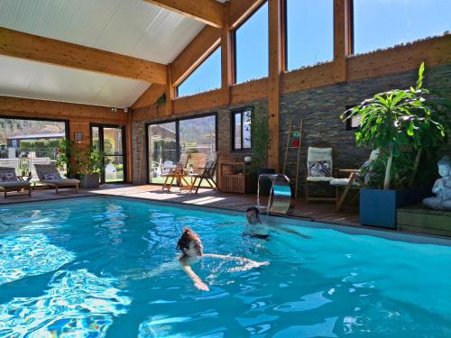 a woman swimming in a swimming pool in a house at TRAPPEUR - Les Chalets du lac Belcaire in Belcaire