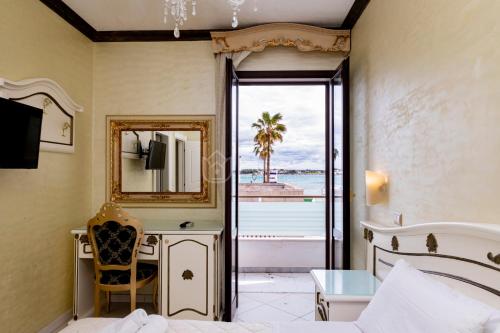 a bedroom with a bed and a mirror and a desk at DIO DEL MARE LUXURY ROOM in Porto Cesareo