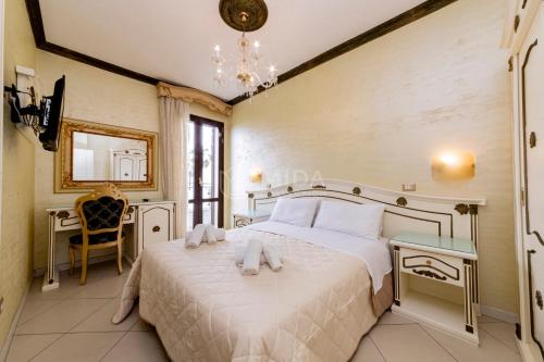 a bedroom with a bed and a table and a chandelier at DIO DEL MARE LUXURY ROOM in Porto Cesareo