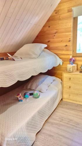a bedroom with two beds and a wooden wall at TRAPPEUR - Les Chalets du lac Belcaire in Belcaire