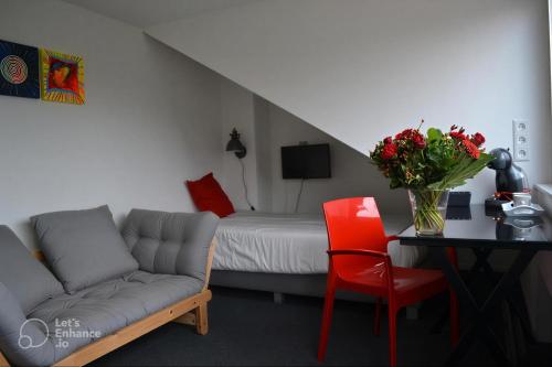 a living room with a couch and a table and a bed at Saskia's logeerhuis in Arnhem