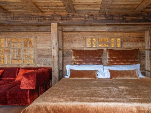 a bedroom with a bed and a couch at Nido sull`Aqua Chalet with Whirlpool in Sigriswil