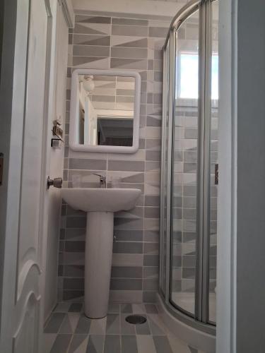 a bathroom with a sink and a mirror and a shower at Little Chatty in Costa Calma