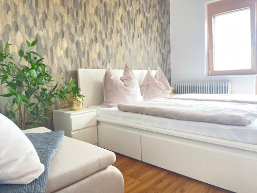 a bedroom with a white bed with a window at Apartment mit Balkon & Bergblick inklusive Parkplatz in Christofberg
