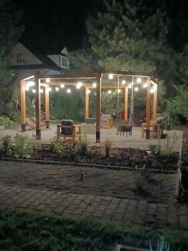 a gazebo with lights in a yard at night at Na Brzysku in Jabłonka