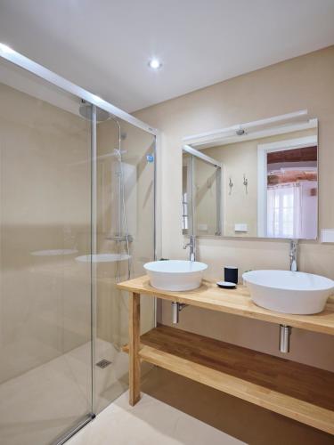 a bathroom with two sinks and a shower at Apartment at Cadaqués Church in Cadaqués