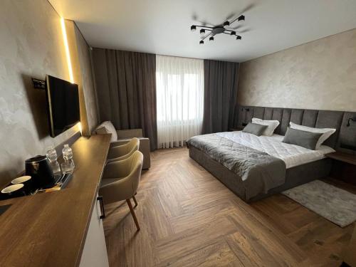 a hotel room with a bed and a desk at Amaro Hotel Uman in Uman
