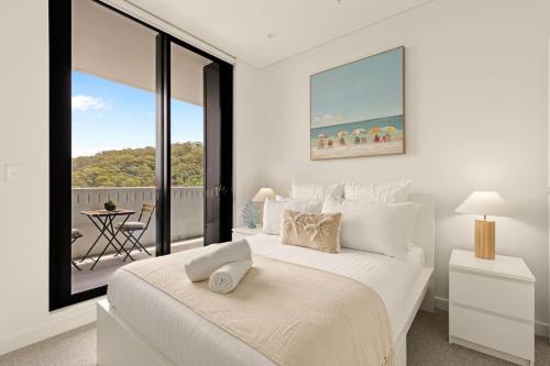 a bedroom with a large white bed with a large window at 2BDR Luxury Apartment Panoramic Views in Gosford