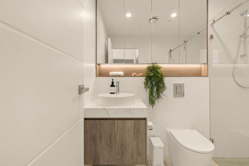 a white bathroom with a toilet and a sink at 2BDR Luxury Apartment Panoramic Views in Gosford