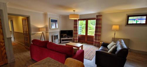 a living room with two couches and a tv at Cherry Tree Cottage in Glencoe