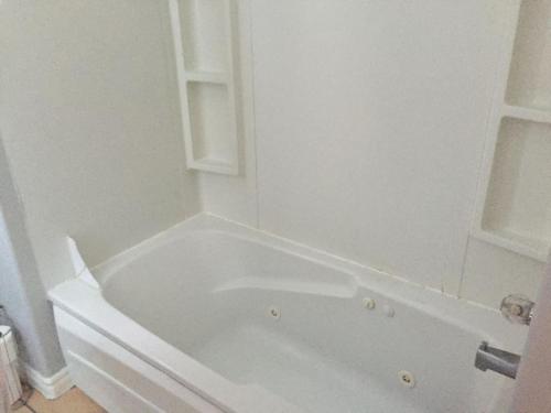 a white bath tub in a white bathroom at Downtown Apt 5 Private Deck Queens Road in St. John's