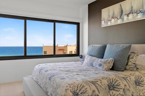 a bedroom with a bed with a view of the ocean at Elegant Beachfront Penthouse | Casa Del Mar Delfin in San José del Cabo