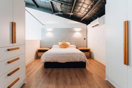 a bedroom with a bed and two night stands at Daybreak Loft. Willunga in Willunga
