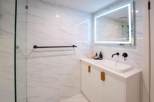 a white bathroom with a sink and a shower at Daybreak Loft. Willunga in Willunga