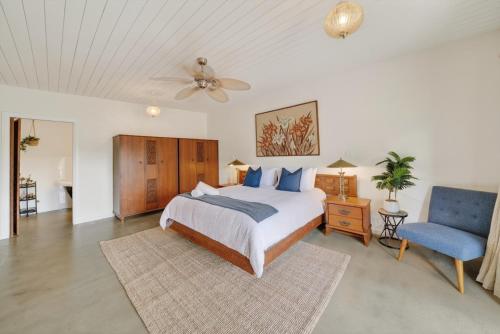 a bedroom with a bed and a blue chair at Forty at Yellow Doors in Goolwa South