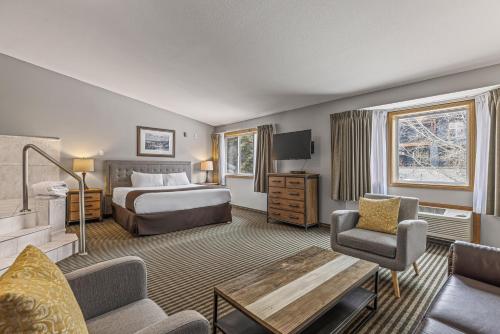 a hotel room with a bed and a couch at Canmore Rocky Mountain Inn in Canmore
