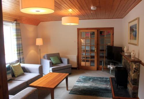 a living room with a couch and a tv at Hawthorn in Glencoe
